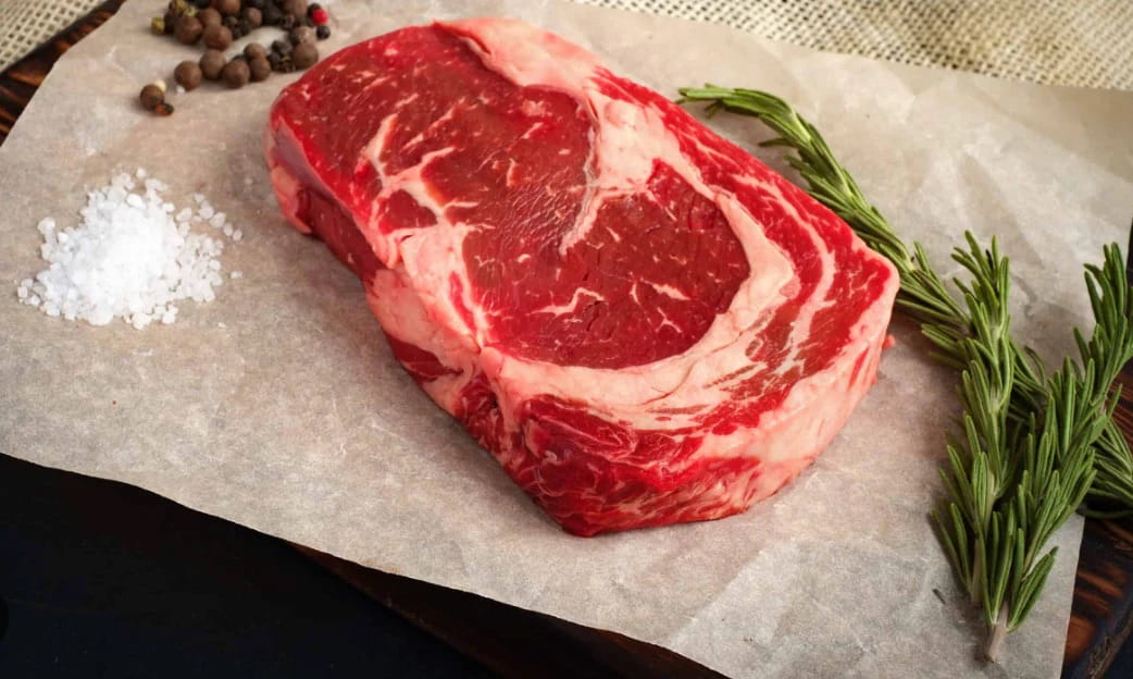 100% grass-fed Delmonico steak on a piece of parchment paper