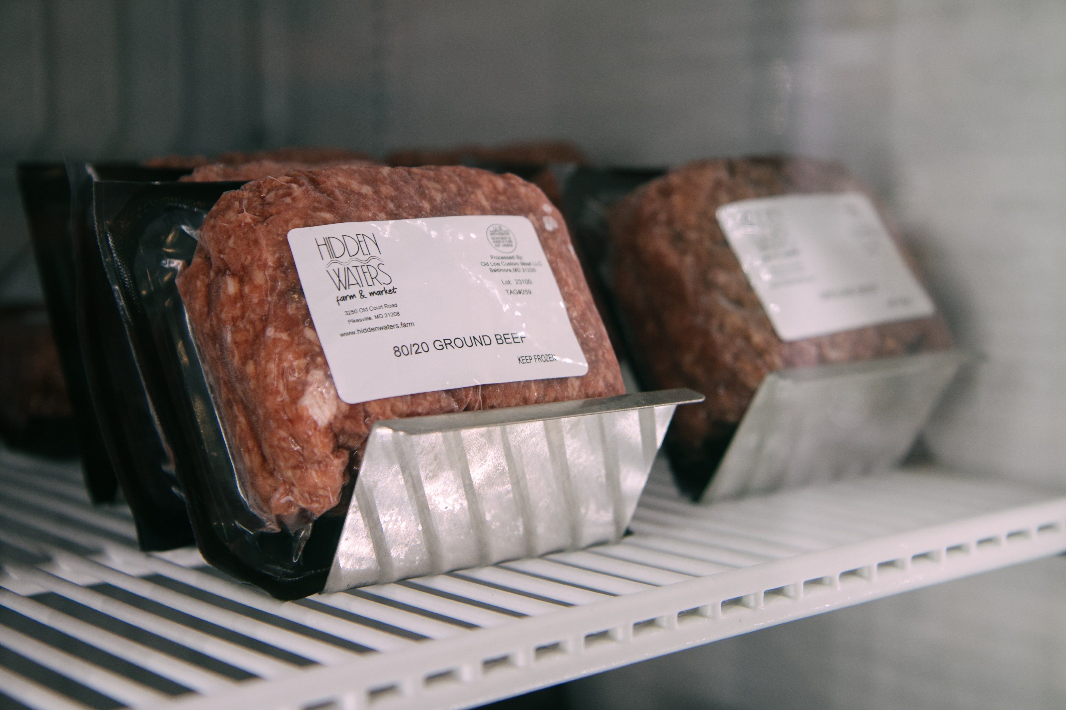 Packaged ground beef in a refrigerator, with labels.
